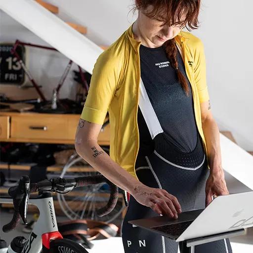 Femme ouvrant le simulateur de vélo BKOOL sur son ordinateur.