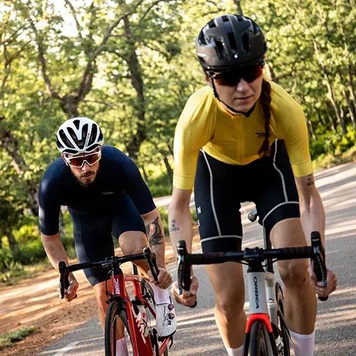 Zwei Radfahrer trainieren auf einer Radstrecke im Freien.