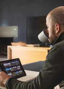 Homme regardant sa tablette avec une application de cyclisme virtuel en intérieur